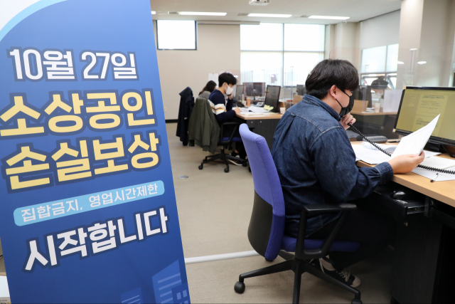 코로나19 방역조치에 따른 소상공인 손실보상금 신청이 시작된 27일 오후 경기도 수원시 경기지방중소벤처기업청에서 근무자들이 신청 전화를 받고 있다. 연합뉴스