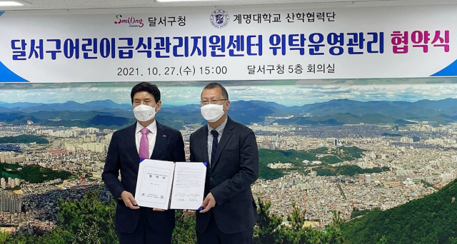 이태훈(왼쪽) 달서구청장과 김범준 계명대 산학협력단장이 협약서를 들어보이고 있다. 달서구 어린이급식관리지원센터 제공
