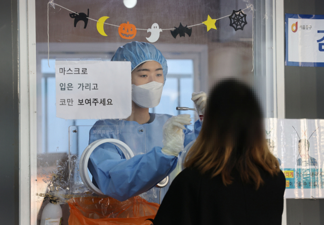 28일 서울역 광장에 마련된 신종 코로나바이러스 감염증(코로나19) 임시 선별검사소에서 의료진이 검체를 채취하고 있다. 연합뉴스