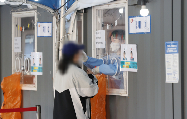 28일 서울역 광장에 마련된 신종 코로나바이러스 감염증(코로나19) 임시 선별검사소에서 의료진이 검체를 채취하고 있다. 연합뉴스