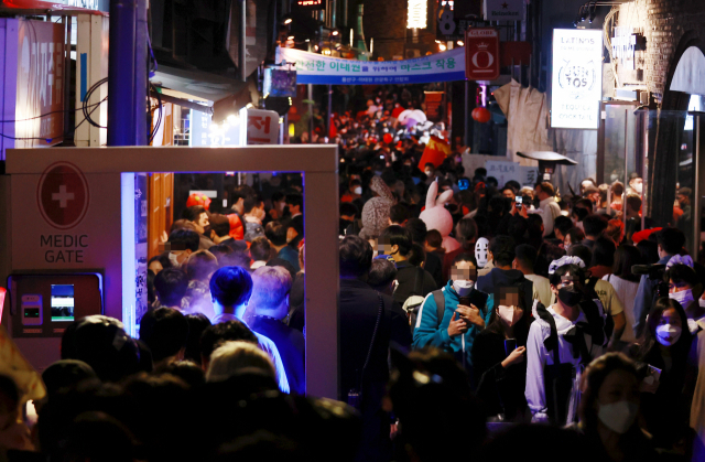 핼러윈 데이를 하루 앞둔 30일 오후 서울 용산구 이태원 세계음식거리를 찾은 시민들이 코로나19 방역 게이트를 지나 거리를 오가고 있다. 연합뉴스