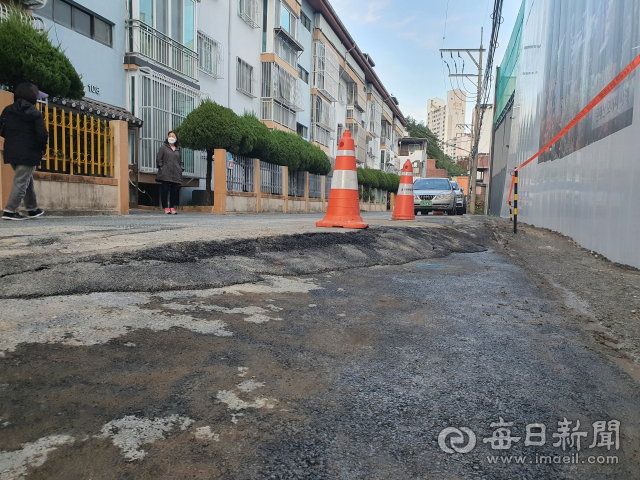 포항 득량지구 재건축 공사현장과 인근 연립주택이 맞닿은 골목길의 아스팔트가 30cm가량 크게 내려앉아 있다. 주민들에 따르면 이곳은 올해 초 보강공사가 벌어졌지만 같은 현상이 반복되고 있다. 매일신문DB