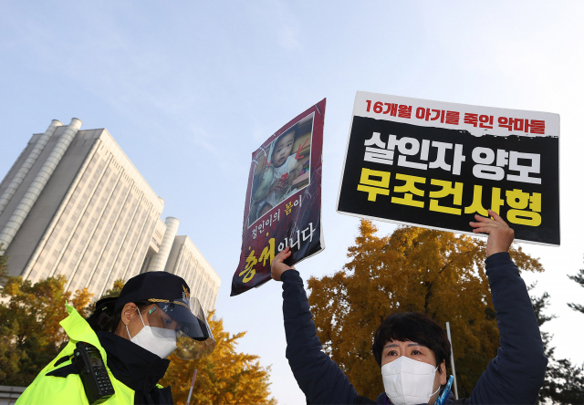 생후 16개월 된 입양아 정인양을 학대해 숨지게 한 혐의로 1심에서 무기징역을 선고받은 양모 장씨의 항소심 결심공판이 열린 5일 오전 서울 서초구 서울고법 앞에서 시민들이 손피켓을 들고 항의하고 있다. 연합뉴스