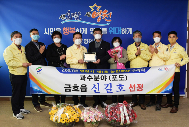 제1호 영천시 농업명장에 선정된 신길호(가운데) 씨가 최기문 시장으로부터 인증패를 전달받고 있다. 영천시 제공