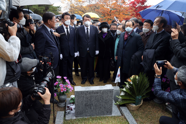국민의힘 윤석열 대선후보가 9일 오후 서울 강북구 국립4.19민주묘지에서 학생혁명 기념탑 참배 후 이기택 전 민주당 총재의 묘소를 살피고 있다. 연합뉴스