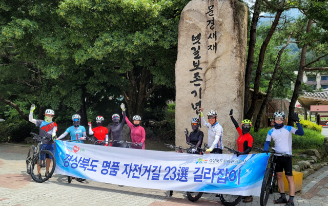 경북 23선 명품 자전거팀이 문경새재 입구에서 인증샷을 남기고 있다.