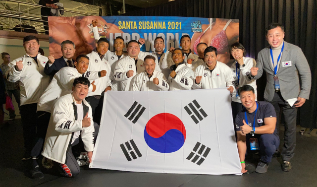 역대 최고의 성적을 거두고 귀국한 보디빌딩 국가대표팀 선수들과 송석영 단장(맨 오른쪽)이 공항에서 파이팅을 외치고 있다. 보디빌딩 협회 제공