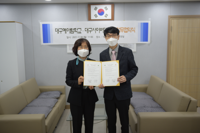 하미애(왼쪽) 대구예아람학교 교장과 이창희 대구사이버대 발달재활학과 학과장이 협약서를 들어보이고 있다. 대구사이버대 제공