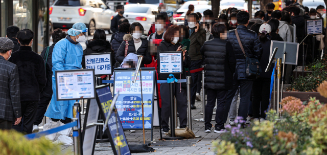 11일 오전 서울 송파구 송파구보건소 선별진료소에서 방호복을 입은 관계자가 신종 코로나바이러스 감염증(코로나19) 검사를 받으러 온 시민을 안내하고 있다. 연합뉴스