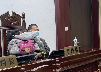 지난 9일 중국에서 열린 한 이혼 재판에서 우는 아이를 안은 채 재판을 진행하는 장 츠치 판사 모습. 사진 웨이보 캡처