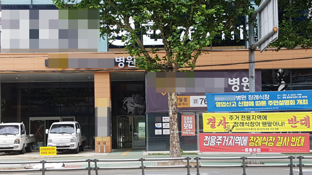 대구 수성구 중동의 한 요양병원에 장례식장이 들어선다는 소식에 주민들이 반발, 급기야는 행정 심판까지 가는 지경에 이르렀다. 사진은 지난 8월 인근 주택가에 사는 주민이 요양병원 내 장례식장 설치 반대를 주장하는 1인 시위를 하는 모습. 독자 제공