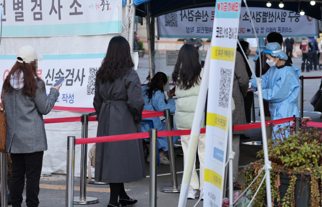 신종 코로나바이러스 감염증(코로나19) 신규 확진이 역대 두 번째인 3천187명을 기록한 17일 오전 서울 중구 서울역 광장 코로나19 임시선별진료소에서 의료진이 검사를 진행하고 있다. 연합뉴스