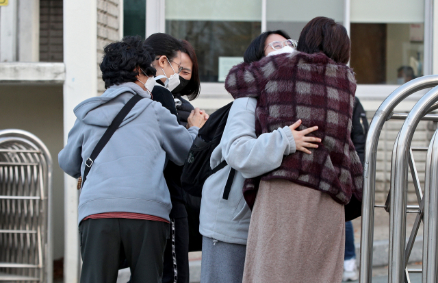 2022학년도 대학수학능력시험일인 18일 오전 대구 수성구 정화여자고등학교 앞에서 수험생이 가족들과 포옹을 나누며 응원을 받고 있다. 김영진 기자 kyjmaeil@imaeil.com