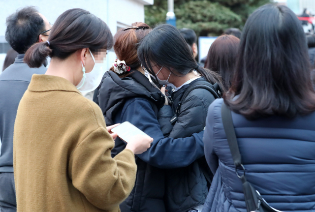 대학수학능력시험(수능)이 시행된 18일 오후 수험생이 가족과 포옹하고 있다. 연합뉴스