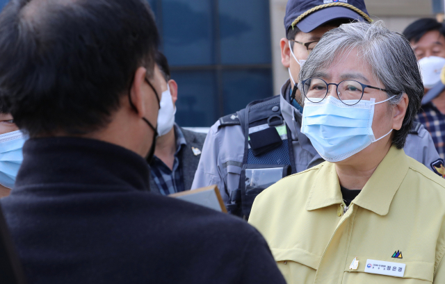 코로나19백신피해자가족협의회(코백회) 회원들이 19일 충북 예방접종 위탁의료기관인 청주시 하나병원 앞에서 추가접종을 하고 병원을 나서는 정은경 질병관리청장을 만나 면담을 요구하고 있다. 연합뉴스