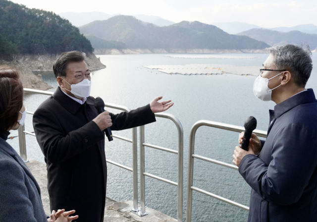 문재인 대통령이 24일 상업발전을 시작한 경남 합천군 합천댐 수상태양광(41MW) 현장을 찾아 박재현 한국수자원공사 사장에게 현황 보고를 받고 질문하고 있다. 댐 호수를 이용한 국내 최대 규모의 부유식 합천댐 수상태양광이 매년 생산하는 전력량은 연간 2만가구에서 사용할 수 있는 수준이다. 연합뉴스