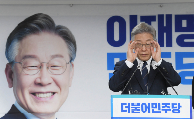 더불어민주당 이재명 대선 후보가 24일 오후 서울 여의도 중앙당사에서 핵심 당직자 일괄 사퇴와 관련해 기자들의 질문에 답하며 안경을 고쳐쓰고 있다. 연합뉴스