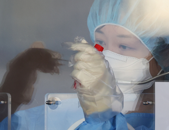 26일 오전 서울역광장에 마련된 코로나19 임시선별검사소에서 의료진이 검체 채취를 하고 있다. 중앙방역대책본부에 따르면 이날 0시 기준 신규확진자 수는 3천901명으로 집계됐다. 한편 최근 남아프리카공화국, 보츠와나, 홍콩 등 3개국에서 신규 변이종 