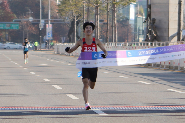 박민호가 28일 열린 2021 서울마라톤 남자부 경기에서 가장 먼저 결승선을 통과하고 있다. 박민호는 이날 서울시 올림픽공원 평화의 문을 출발해 잠실종합운동장으로 들어오는 42.195㎞ 레이스를 2시간14분35초에 달렸다. 연합뉴스