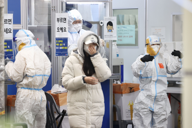 신종 코로나바이러스 감염증(코로나19) 신규 확진자 수가 3천928명을 기록한 28일 오전 서울 송파구보건소 선별진료소에서 의료진이 추가 감염을 막기 위해 방호복 틈에 테이프를 붙인 채 업무를 보고 있다. 연합뉴스
