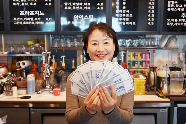 청송사랑화폐로 코로나 19를 극복하고 있다는 청송지역 한 카페 주인이 손님에게 받은 화폐를 들어보이고 있다. 청송군 제공