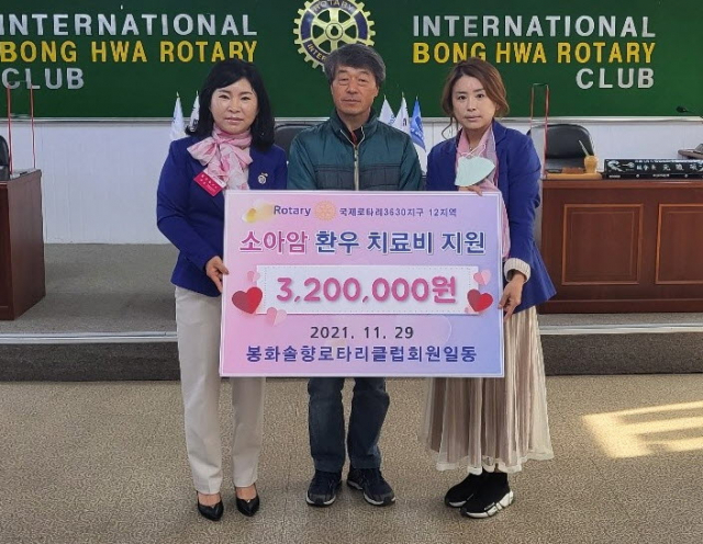 봉화 솔향로타리(회장 이순영) 회원들이 조 군의 아버지에게 성금을 전달하고 있다. 마경대 기자