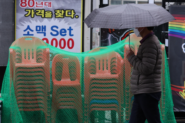 30일 서울 종로의 한 식당가에 한 주점이 내놓은 간이 의자가 쌓여 있다. 코로나19 변이 바이러스인 '오미크론'이 세계적으로 유행할 조짐을 보이면서 위드 코로나 정책으로 잠시 회복세를 보이던 자영업이 다시 위축될 것으로 우려된다. 연합뉴스