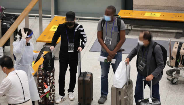 전 세계 보건당국이 남아공에서 보고된 코로나19 변이 오미크론 방역을 위한 빗장을 채우고 있는 28일 오후 인천공항 입국장에서 에티오피아 항공을 이용해 아디스아바바에서 출발한 승객들이 격리 뒤 검사를 받기 위해 방역 관계자의 안내를 받고 있다. 정부는 새로운 코로나19 변이 바이러스인 