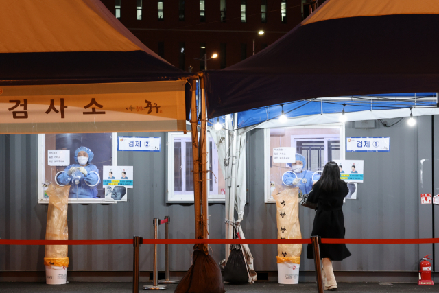 30일 밤 서울역 광장에 마련된 중구 임시선별검사소에서 한 시민이 검사를 받고 있다. 이날 0시부터 오후 6시까지 전국에서 코로나19 양성 판정을 받은 신규 확진자는 총 2천473명으로 집계됐다. 전날 같은 시간보다 662명 증가했다. 연합뉴스