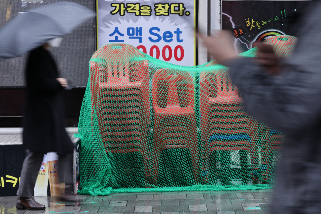 30일 서울 종로의 한 식당가에 한 주점이 내놓은 간이 의자가 쌓여 있다. 코로나19 변이 바이러스인 '오미크론'이 세계적으로 유행할 조짐을 보이면서 위드 코로나 정책으로 잠시 회복세를 보이던 자영업이 다시 위축될 것으로 우려된다. 연합뉴스