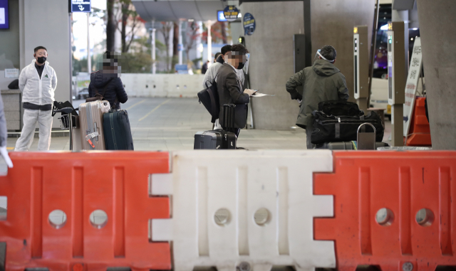 코로나19의 새로운 변이 바이러스인 오미크론 확진자 국내 추가유입을 막기 위한 해외입국자 격리 강화 조치가 시행된 3일 오후 인천국제공항 제1여객터미널에서 한국과 아프리카 지역을 오가는 유일한 직항편인 에티오피아(아디스아바바)발 여객기 탑승자들이 자가격리시설로 이동하는 버스에 탑승을 기다리고 있다. 연합뉴스