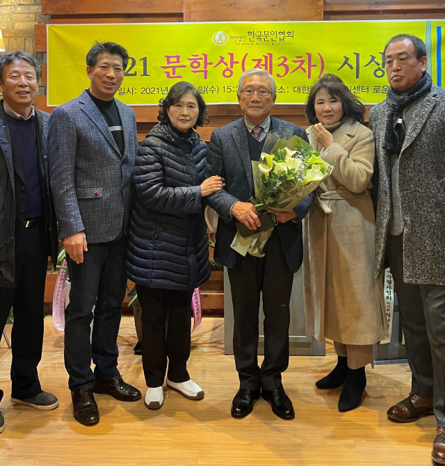 경북 상주의 박찬선 시인이 지난 1일 올해의 한국문학상을 수상한 뒤 꽃다발을 들고 지인들과 기념촬영을 하고 있다. 문인협회 제공
