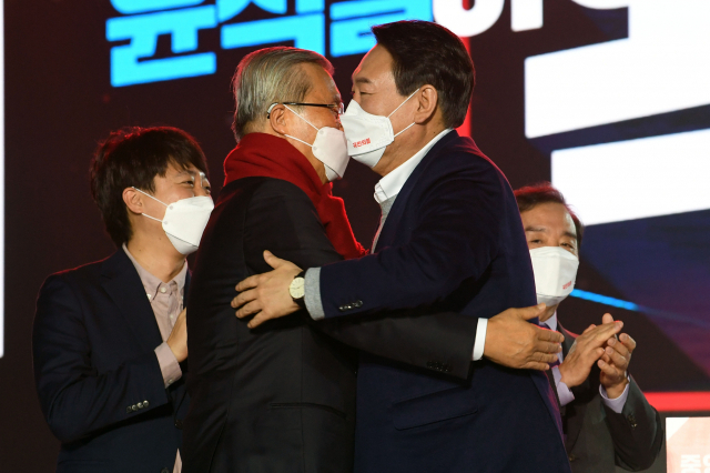 국민의힘 윤석열 대선 후보가 6일 오후 서울 송파구 올림픽공원 체조경기장에서 열린 국민의힘 제20대 대통령선거 선거대책위원회 출범식에서 김종인 총괄선대위원장에게 빨간색 목도리를 매준 뒤 포옹하고 있다. 연합뉴스