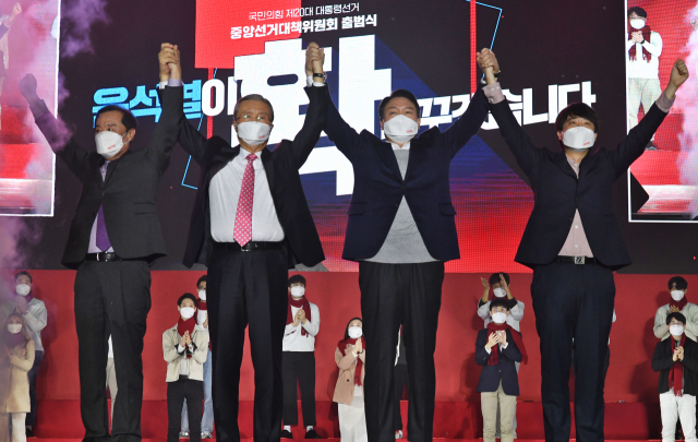 국민의힘 윤석열 대선 후보가 6일 오후 서울 송파구 올림픽공원 체조경기장에서 열린 국민의힘 제20대 대통령선거 선거대책위원회 출범식에서 김종인 총괄선대위원장, 이준석, 김병준 상임선대위원장과 손을 맞잡고 인사하고 있다. 연합뉴스
