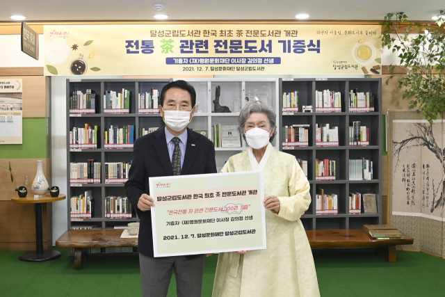 김문오 달성군수가 전통차 전문도서관 개관식에서 김의정 명원문화재단 이사장으로부터 차 관련 도서를 기증받고 있다. 달성군립도서관 제공