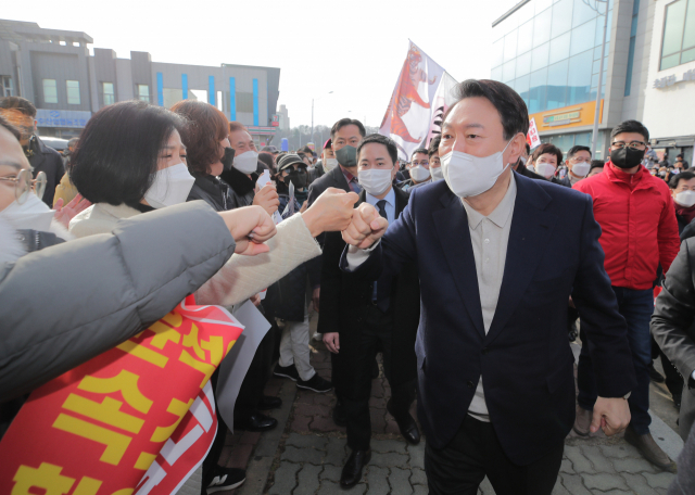 국민의힘 윤석열 대선 후보가 11일 오전 강원 속초시 대포어촌계 어업인복지회관에서 열린 강원도 살리기 현장 간담회에 참석하며 지지자들과 인사하고 있다. 연합뉴스