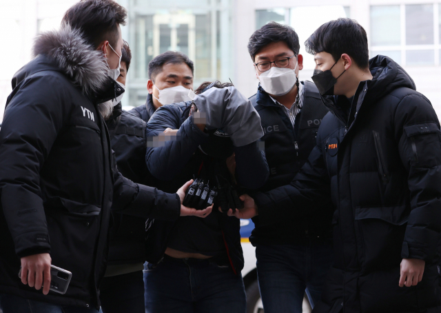 교제했던 여성의 집을 찾아가 가족을 살해한 이모씨가 12일 오후 서울 송파구 서울동부지법에서 열린 영장실질심사에 출석하기 위해 법정으로 향하고 있다. 연합뉴스