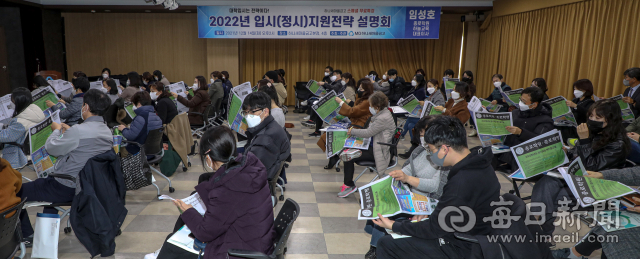 코로나19 사태 속에서도 등용문을 향한 여정은 멈추지 않고 계속된다. 2022학년도 수시모집 일정이 마무리돼 가면서 30일 시작되는 정시모집에 관심이 쏠리고 있다. 최근 대구시 남구 하나새마을금고 본점에서 열린 한 학원의 정시 지원 전략 설명회 풍경. 수험생과 학부모들이 정시 지원 배치기준표를 살펴보고 있다. 안성완 기자 asw0727@imaeil.com