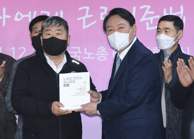국민의힘 윤석열 대선 후보가 15일 오전 서울 여의도 한국노총에서 정책간담회를 하기 전 김동명 위원장으로부터 노동자의 요구를 담은 책자를 전달받고 있다. 국회사진기자단