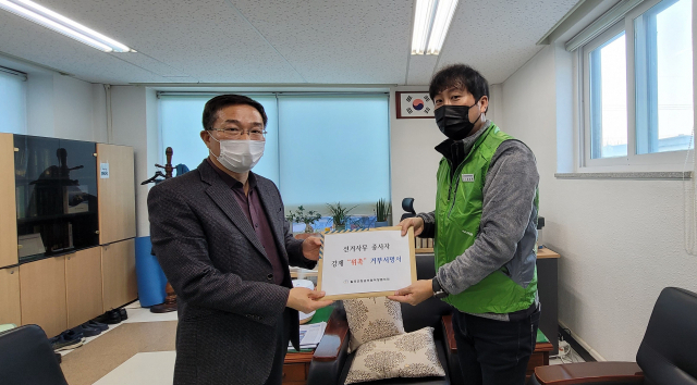 장성원(오른쪽) 칠곡군청공무원직장협의회장이 권형우 칠곡군선거관리위원회 사무국장에게 