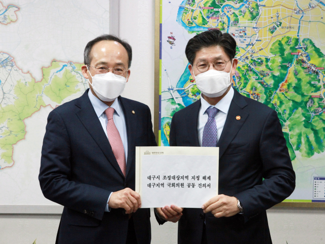 추경호 국민의힘 대구시당위원장(사진 왼쪽)이 20일 대구시 조정대상지역 지정 해제 관련 대구지역 국회의원 공동 건의서를 노형욱 국토부 장관에게 전달하고 있다. 추경호 의원실 제공.