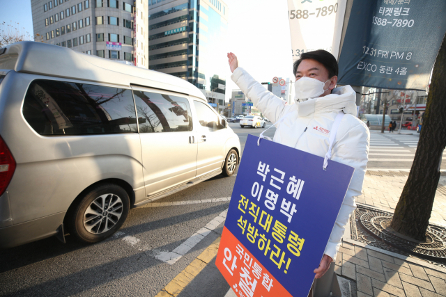 국민의당 안철수 대선 후보가 20일 오전 대구 중구 지하철 2호선 경대병원역 인근에서 이명박·박근혜 전 대통령의 석방을 촉구하는 피켓을 들고 출근길 시민에게 인사하고 있다. 연합뉴스