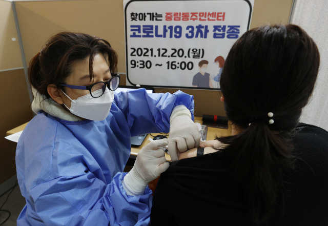 20일 서울 중구 중림동주민센터에서 의료진이 신종 코로나바이러스 감염증(코로나19) 백신 3차 접종을 하고 있다. 서울 중구는 백신 3차 접종률을 높이기 위해 이날부터 열흘간 동 주민센터에서 방문접종팀을 운영한다. 백신 접종 대상자는 18세 이상으로 2차 접종 후 3개월이 지난 주민이다. 연합뉴스