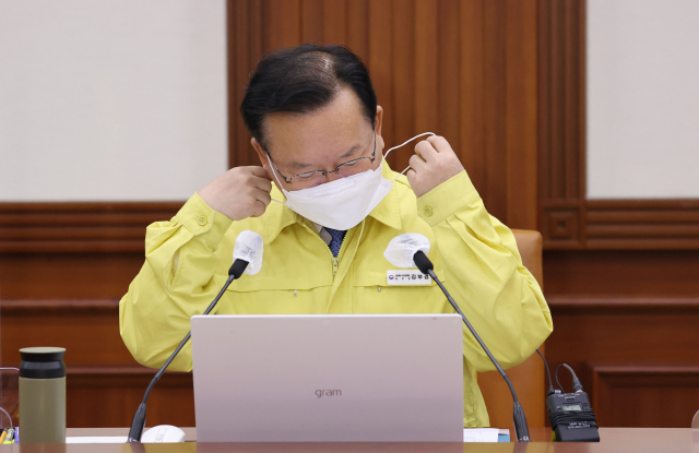 김부겸 국무총리가 22일 오전 정부서울청사에서 열린 코로나19 대응 중앙재난안전대책본부 회의에서 발언하기 위해 마스크를 벗고 있다. 연합뉴스