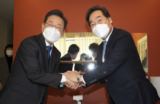 더불어민주당 이재명 대선 후보(왼쪽)와 이낙연 전 대표가 지난 2021년 12월 23일 서울 중구 달개비 식당에서 열린 오찬회동에서 손을 잡고 인사하고 있다. 연합뉴스