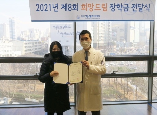 대구자생한방병원 이제균 병원장(오른쪽)이 장학금을 학부모에게 전달한 뒤 기념 사진을 촬영하고 있다. 대구자생한방병원 제공
