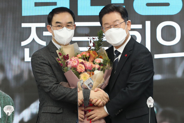 더불어민주당 이재명 대선후보가 10일 오전 서울 영등포구 더불어민주당사에서 열린 바른미래당 출신 김관영, 채이배 전 의원의 입당식에서 채이배 전 의원에게 꽃다발을 주고 있다. 연합뉴스