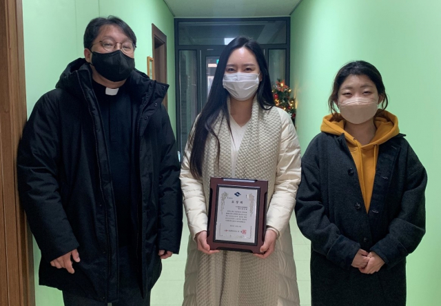 정민화(가운데) 구미가톨릭근로자문화센터 팀장이 구미가톨릭근로자문화센터(센터장 고영일 신부·왼쪽) 관계자들부터 축하를 받으며 기념촬영하고 있다. 구미가톨릭근로자문화센터 제공