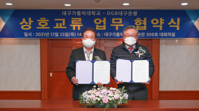 우동기(왼쪽) 대구가톨릭대 총장과 임성훈 대구은행장이 협약서를 들어보이고 있다. 대구가톨릭대 제공