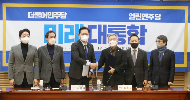 더불어민주당 송영길 대표와 열린민주당 최강욱 대표가 26일 오전 국회 의원회관에서 양당 통합 합의문에 서명한 뒤 악수하고 있다. 왼쪽부터 더불어민주당 협상대표 강훈식, 우상호, 송영길 대표, 열린민주당 최강욱 대표, 협상대표 정봉주, 김의겸. 연합뉴스